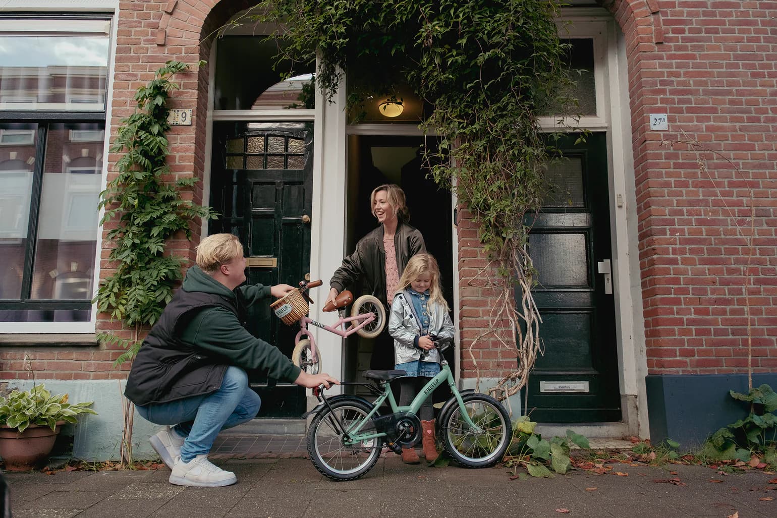 A family collecting a refurbished BikeFlip children's bike on their doorstep